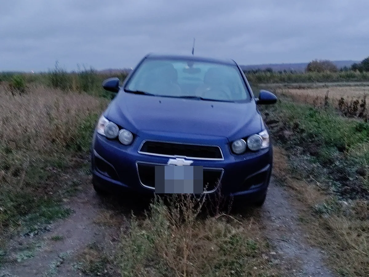 Chevrolet Sonic sedan on a dirt track in a field, front view, your photo